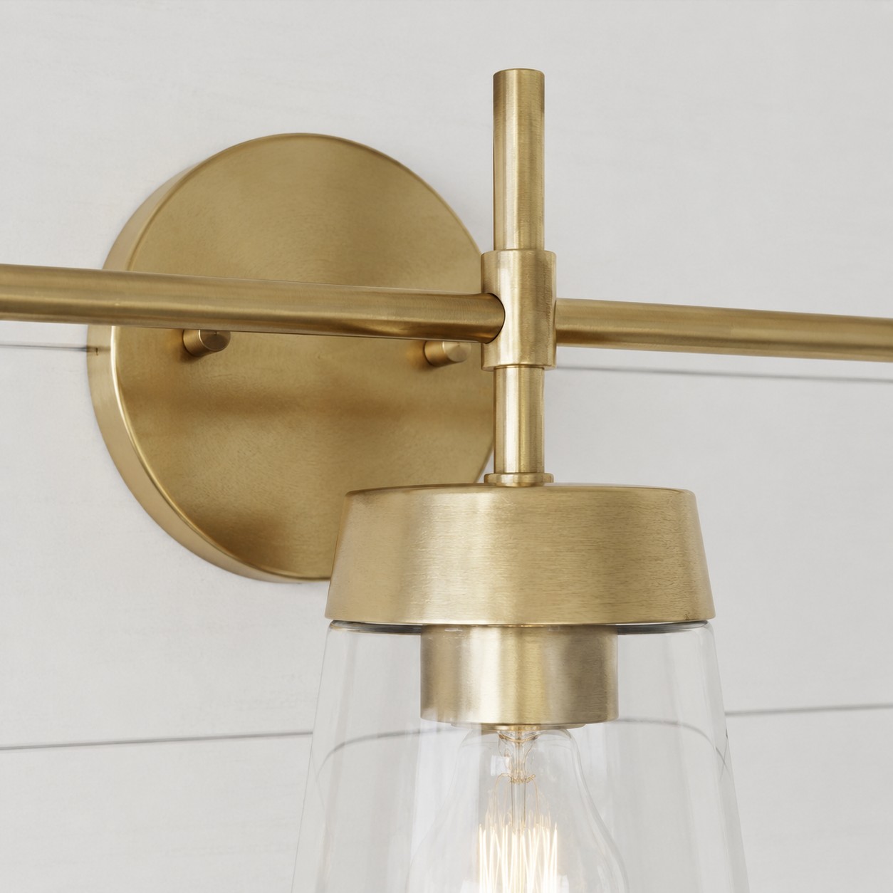 Brushed brass vanity wall light backplate and arm detail