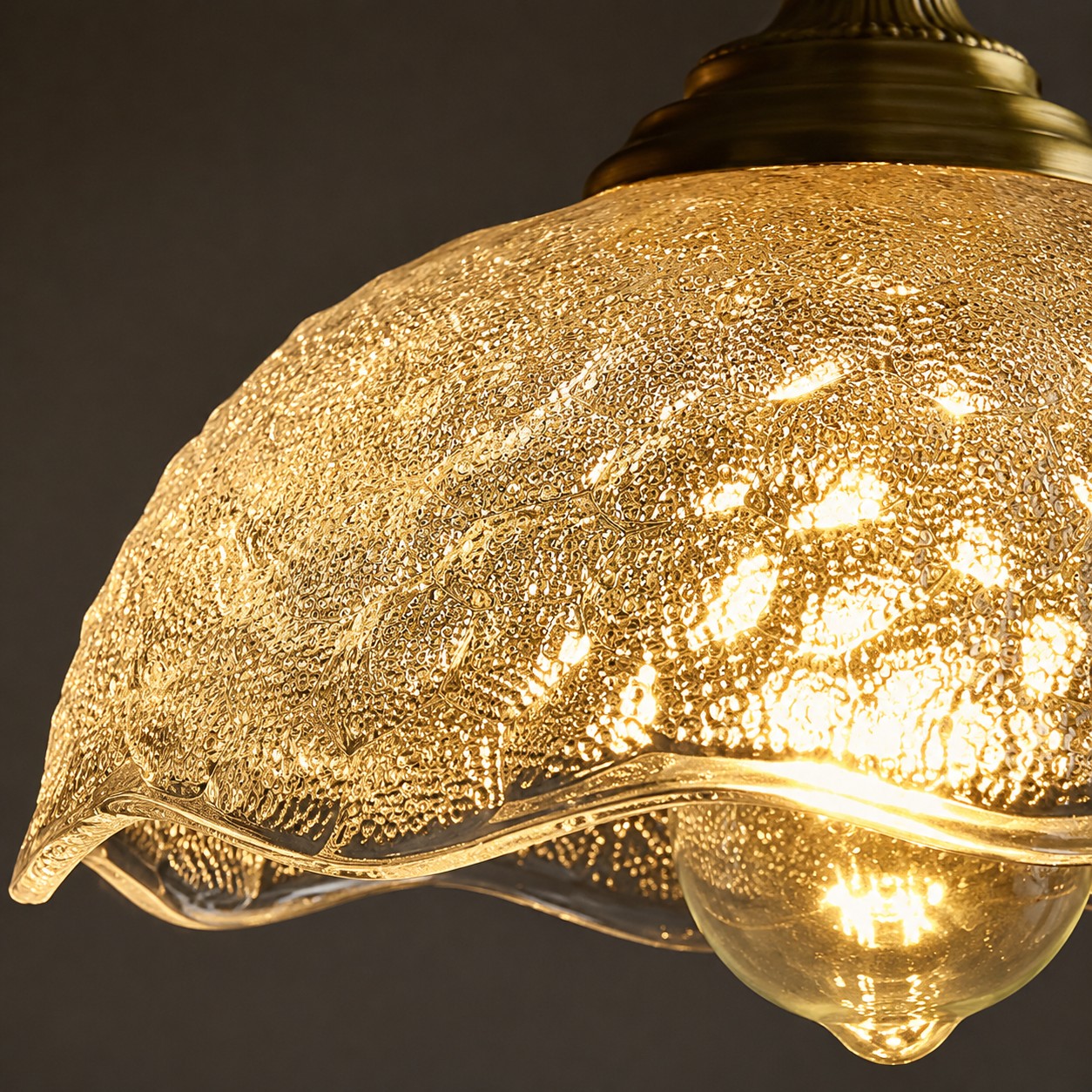 Clear pressed glass shade glowing close-up