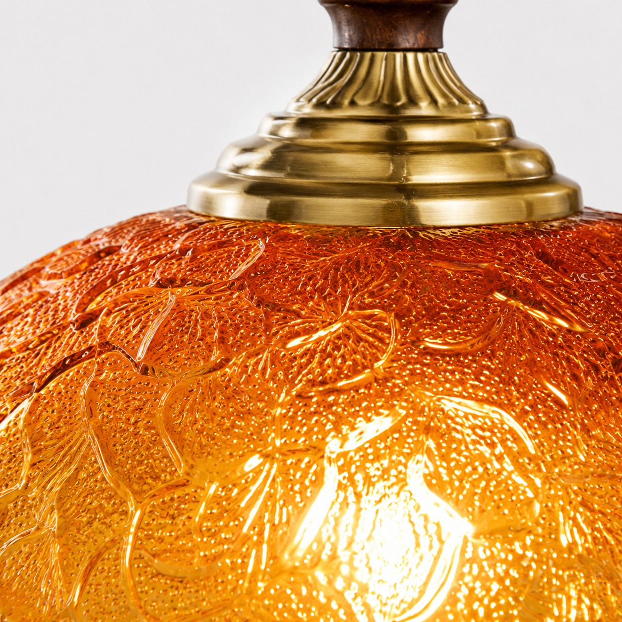 Amber pressed glass and brass-toned cap close-up
