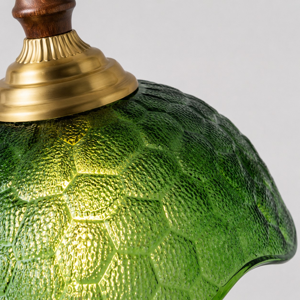 Green pressed glass and brass-toned cap close-up