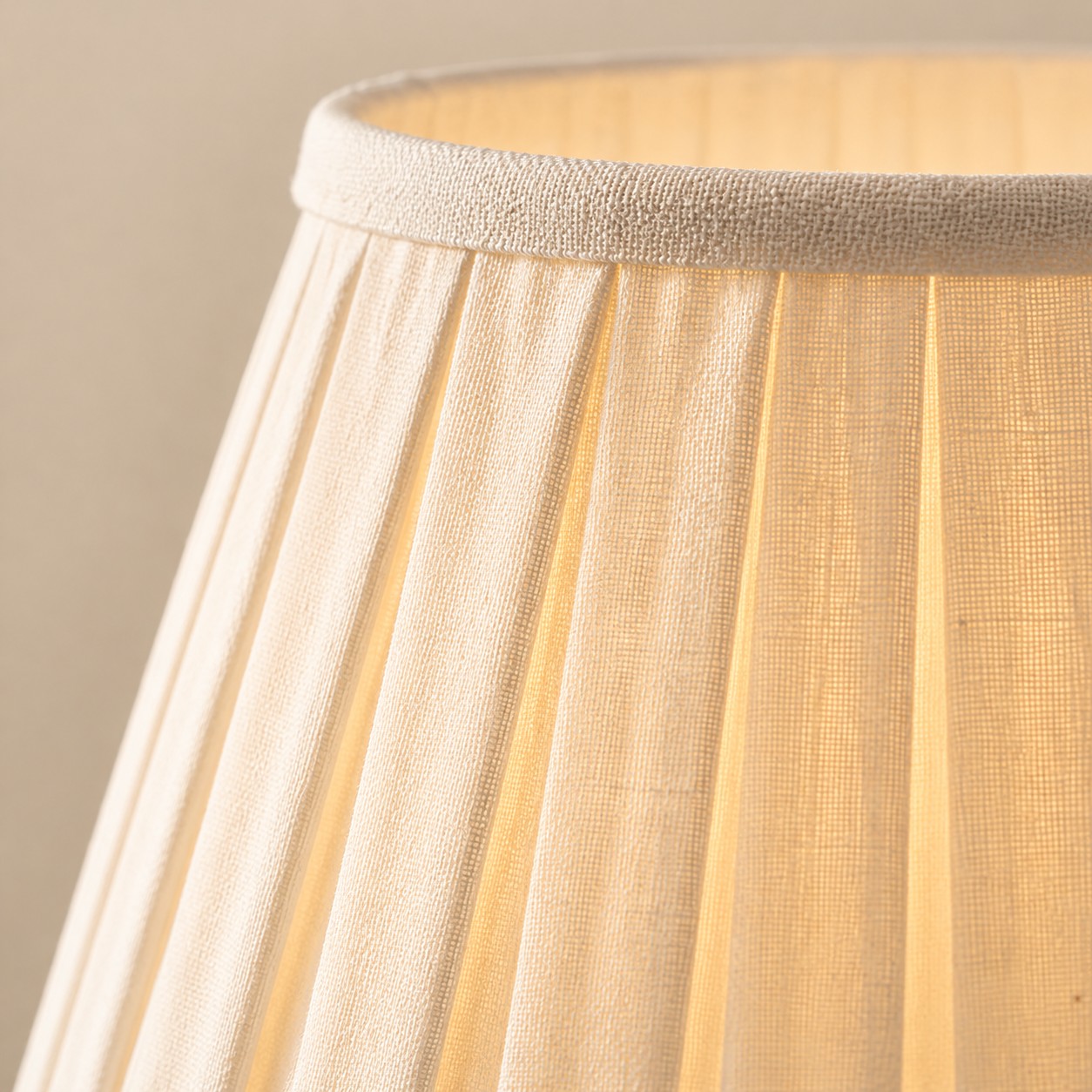 Close view of the pleated linen shade with light showing through the weave