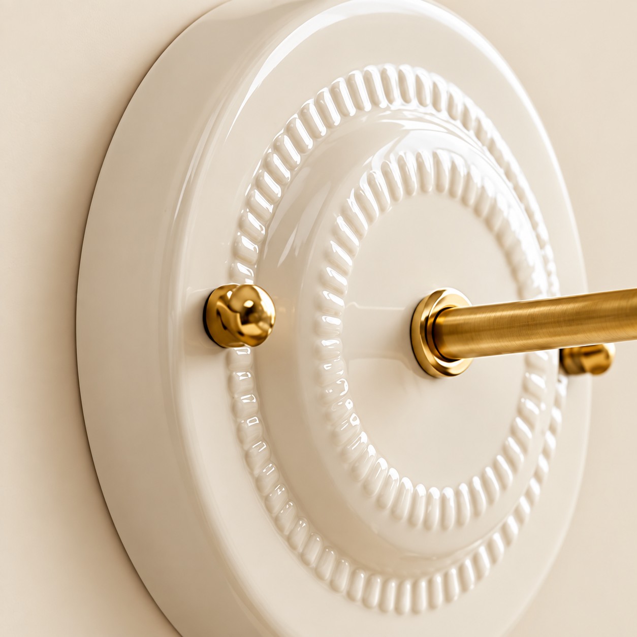 Cream glazed ceramic backplate with concentric beaded rings and a brass stem