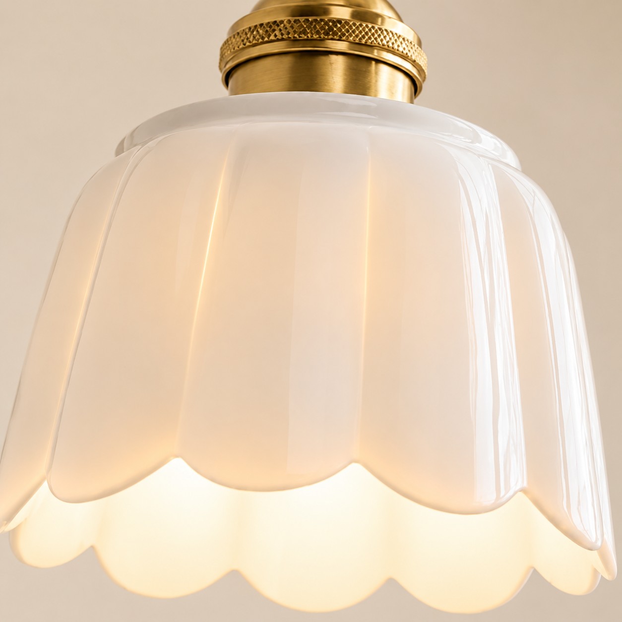 Lit fluted ceramic flower shade with a scalloped rim and warm inner glow