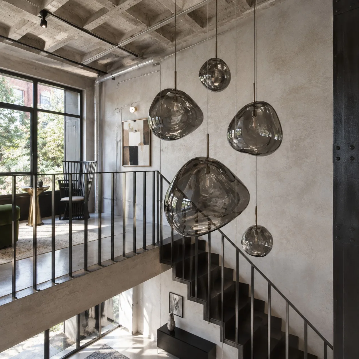 Smoked glass pendants beside a black stair rail